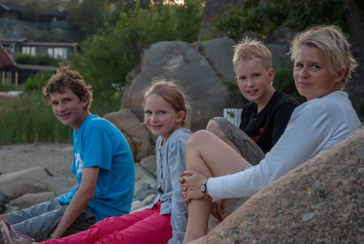Portrait of smiling mother and children sitting outdoors