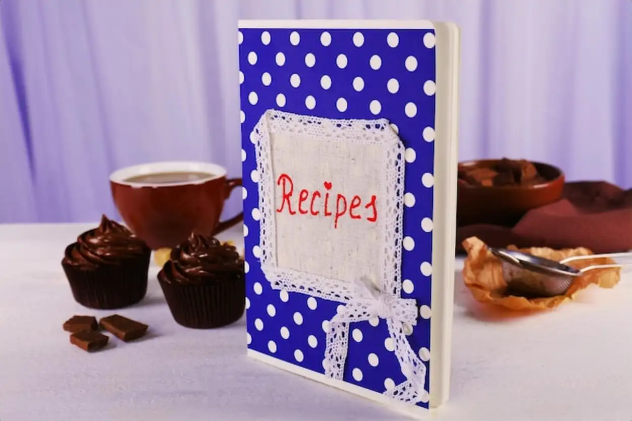 Recipe book on a table with ingredients for baking