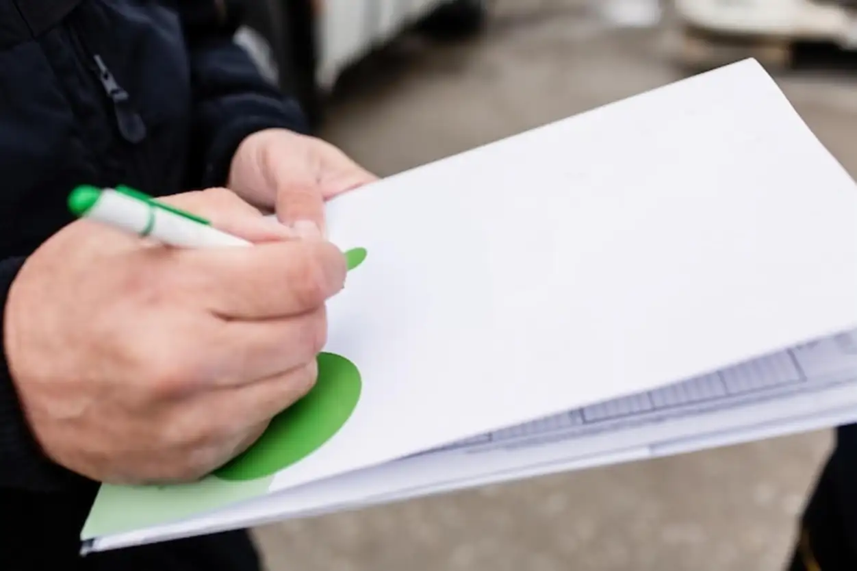 The truck driver and the engineer discuss together the data in the document near the truck