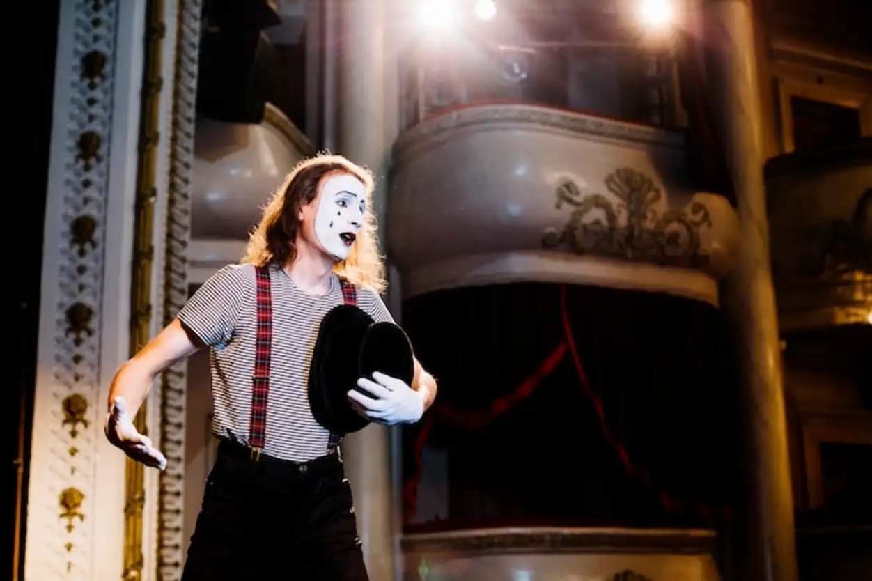 Sad male mime artist rehearsing in the auditorium