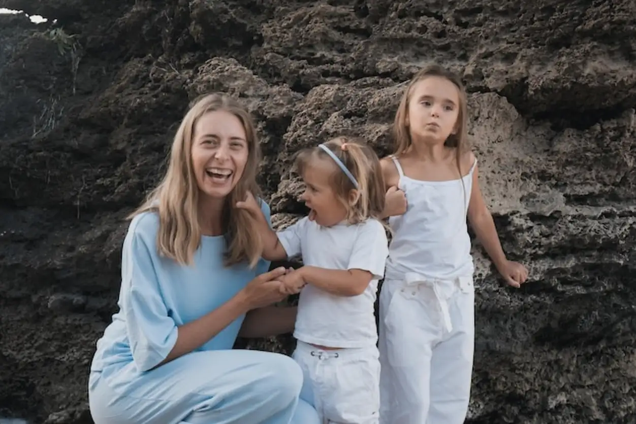 Mothers love Mom hugs her daughters kisses and plays tenderness and care Friendly family at home and on vacation