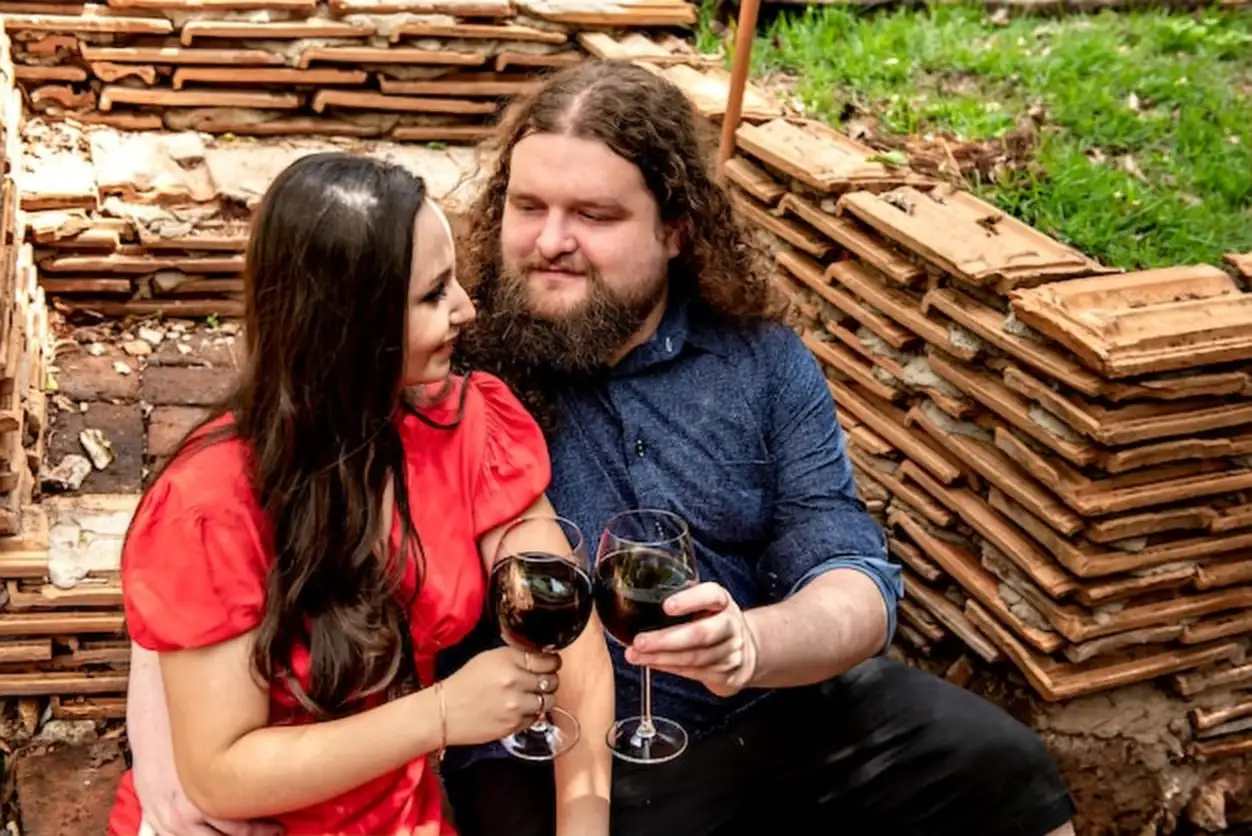Passionate couple in the garden of a country house toasting with glasses of wine