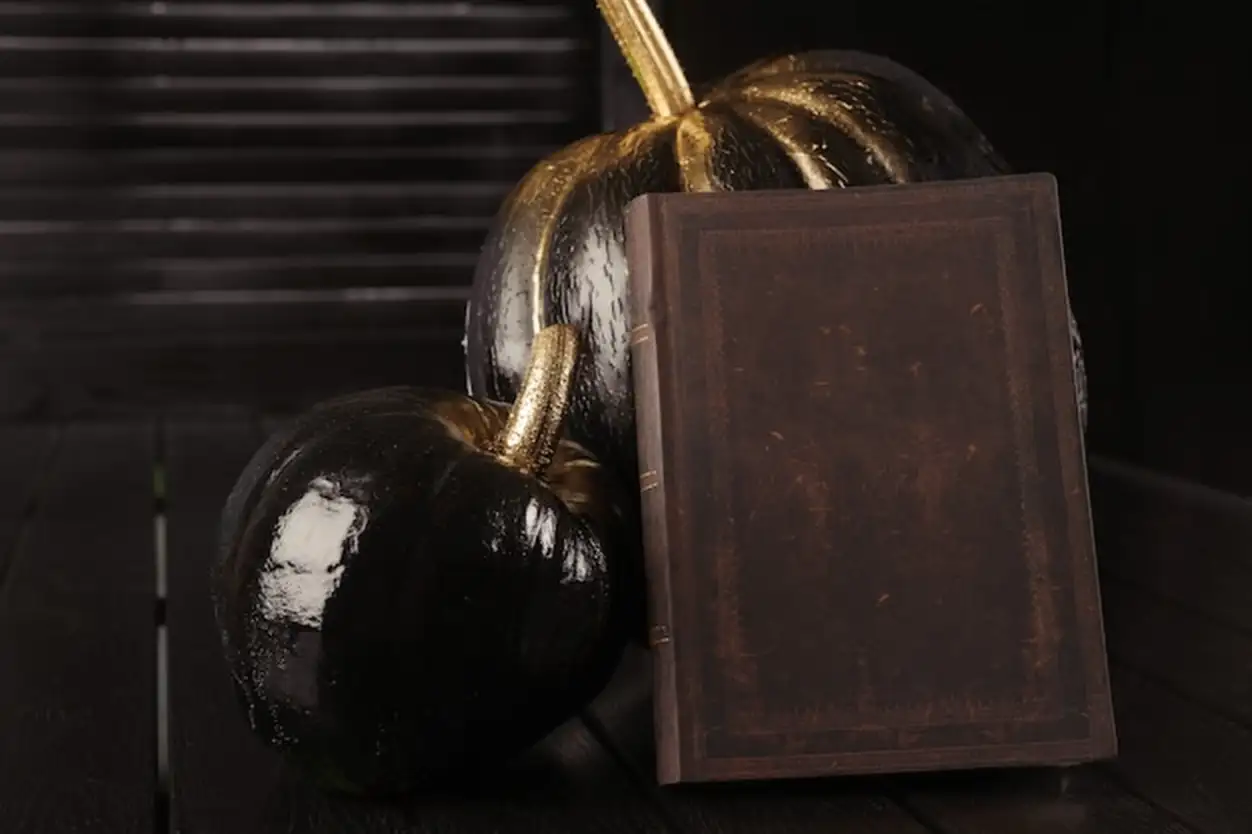 Black pumpkin and book. Home decoration for Halloween in the modern style. Horizontal.