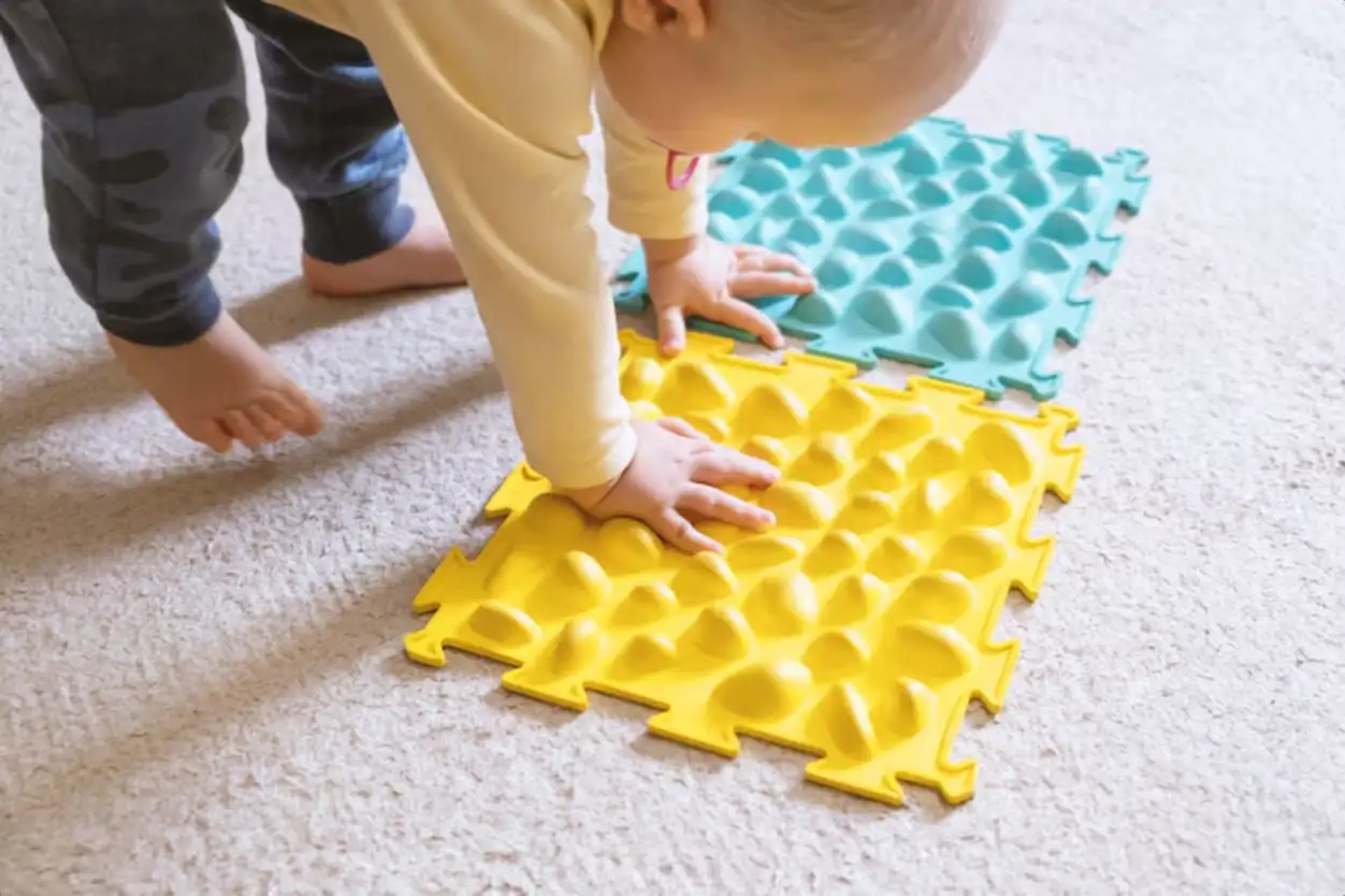 Small baby play with the ribbed rug.