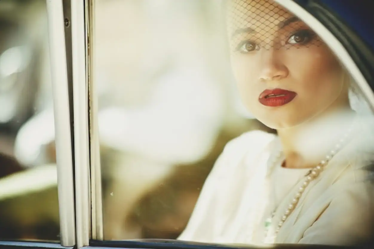 Stunning mysterious woman sits in a retro car