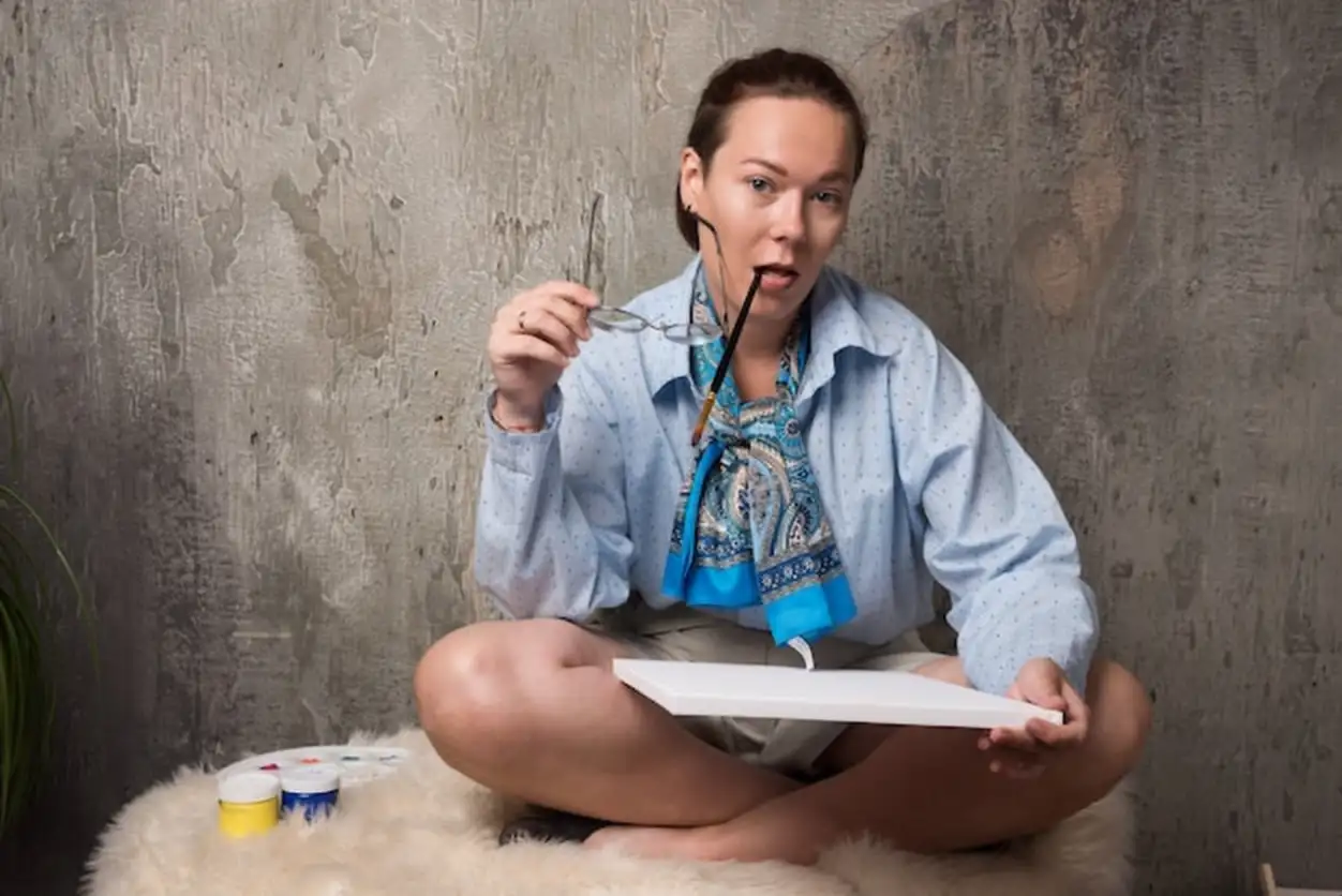 Woman sitting with canvas and brush on marble background . High quality photo